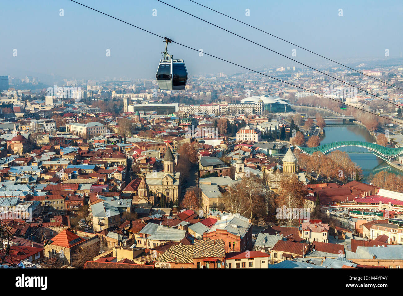 Tbilisi vecchie strade di città, Kura river, con vecchie cattedrali e funivia in primo piano, Georgia Foto Stock