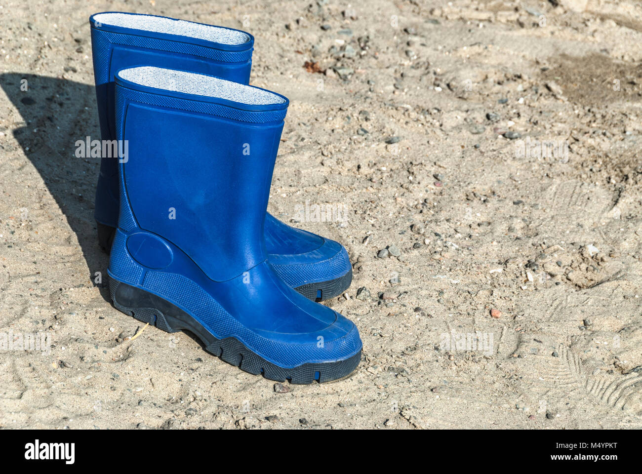 Blue stivali di gomma in piedi sulla spiaggia Foto Stock