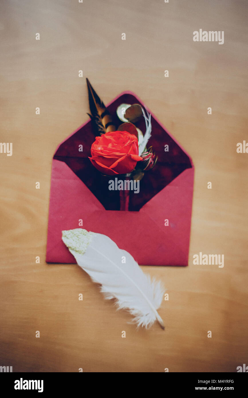 Busta boutonniere inviti gli anelli di nozze sulla tavola presso l'hotel Foto Stock