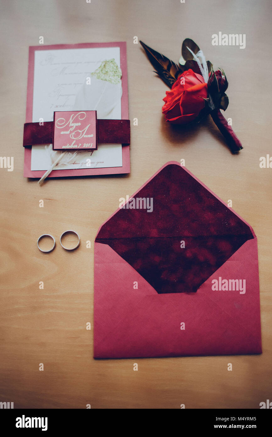 Busta boutonniere inviti gli anelli di nozze sulla tavola presso l'hotel Foto Stock