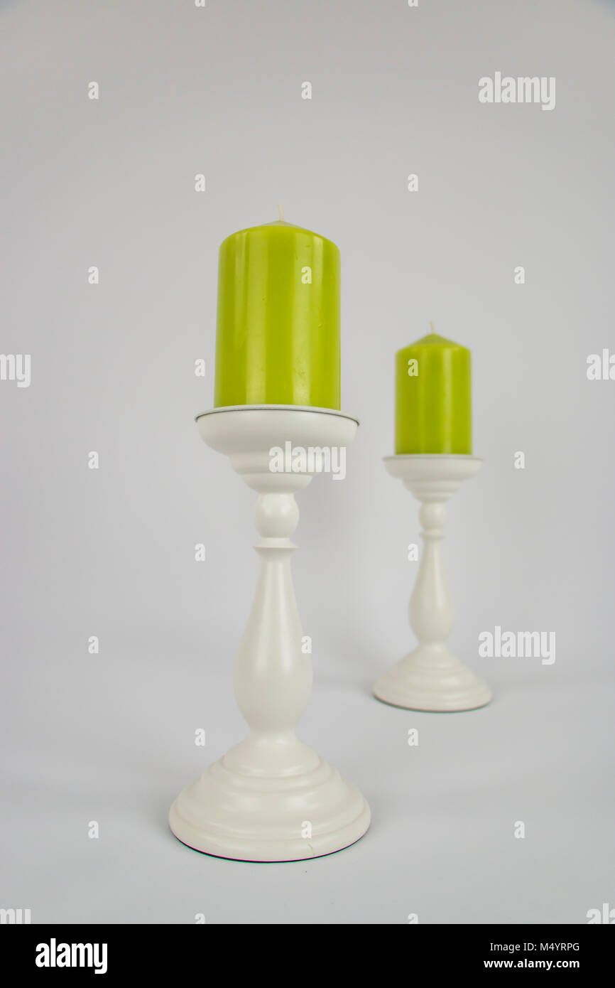 Due verde lime candele su bianco portacandele Foto Stock
