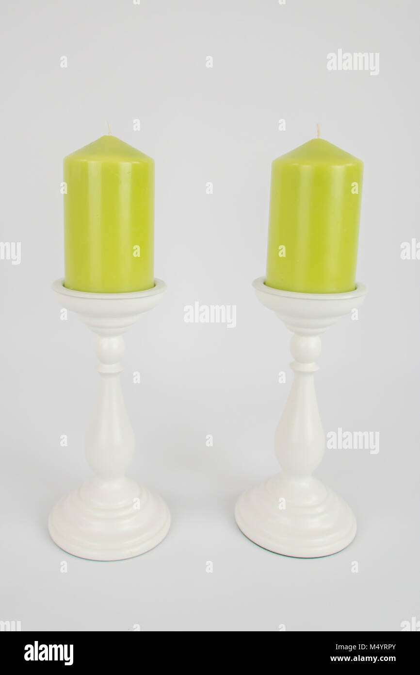 Due verde lime candele su bianco portacandele Foto Stock