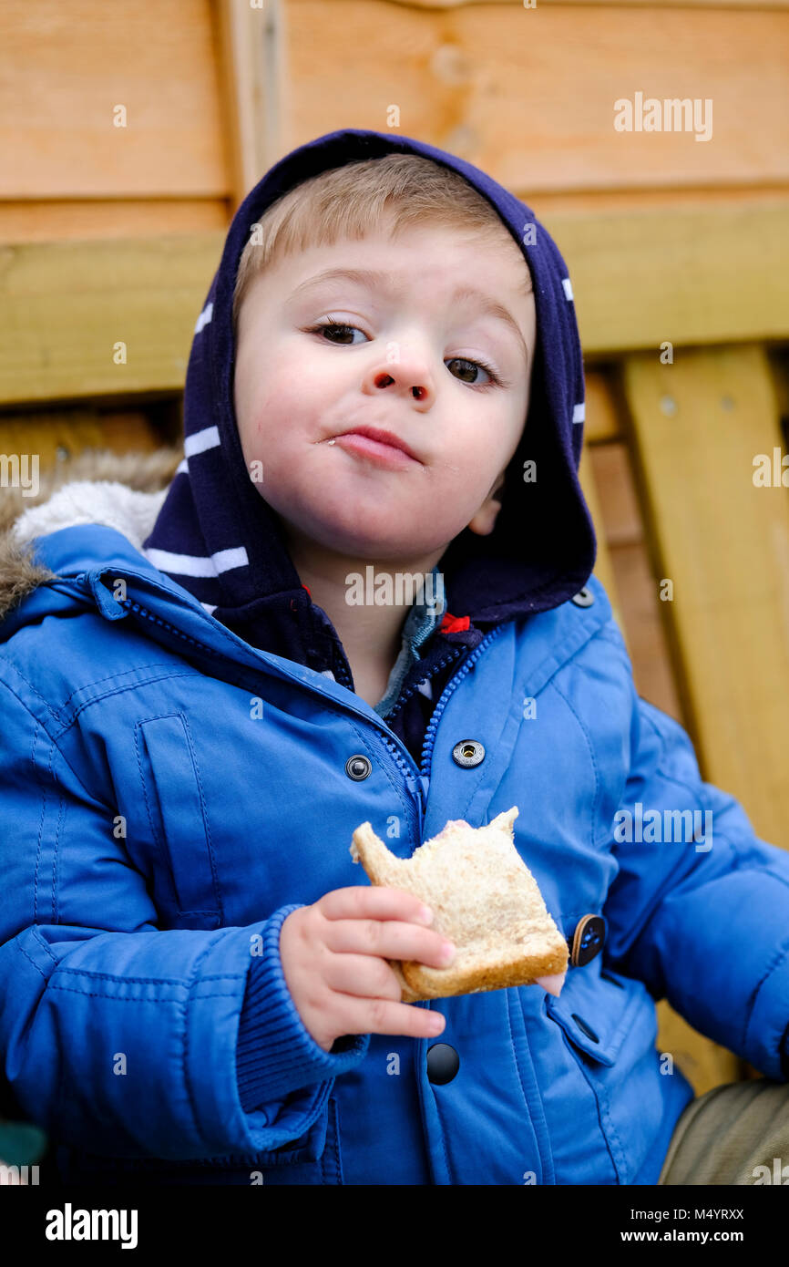 Il Toddler fuori a mangiare un panino Foto Stock