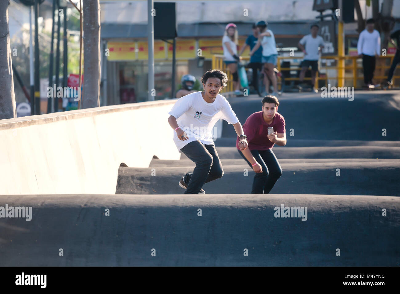 Vista frontale di due giovani uomini skateboarding in skate park, Canggu, Bali, Indonesia Foto Stock