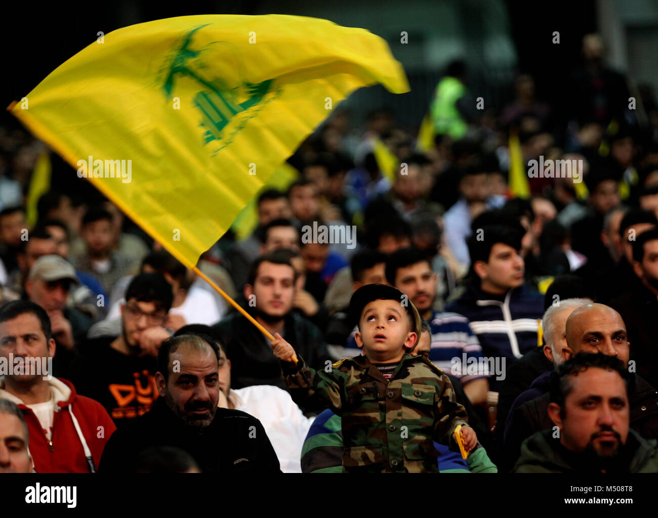 16 febbraio 2018, Libano, Beirut: un bambino oscilla una bandiera di Hezbollah durante un memoriale di servizio in onore dei tre alti rappresentanti di Hezbollah che furono uccisi dagli israeliani. Foto: Marwan Naamani/dpa Foto Stock