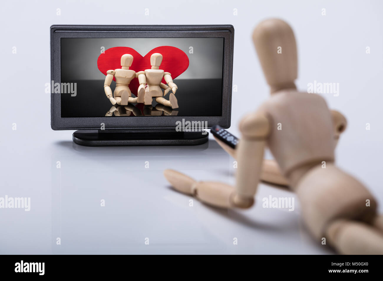 La figura di legno che giace sul piano di guardare la televisione Foto Stock
