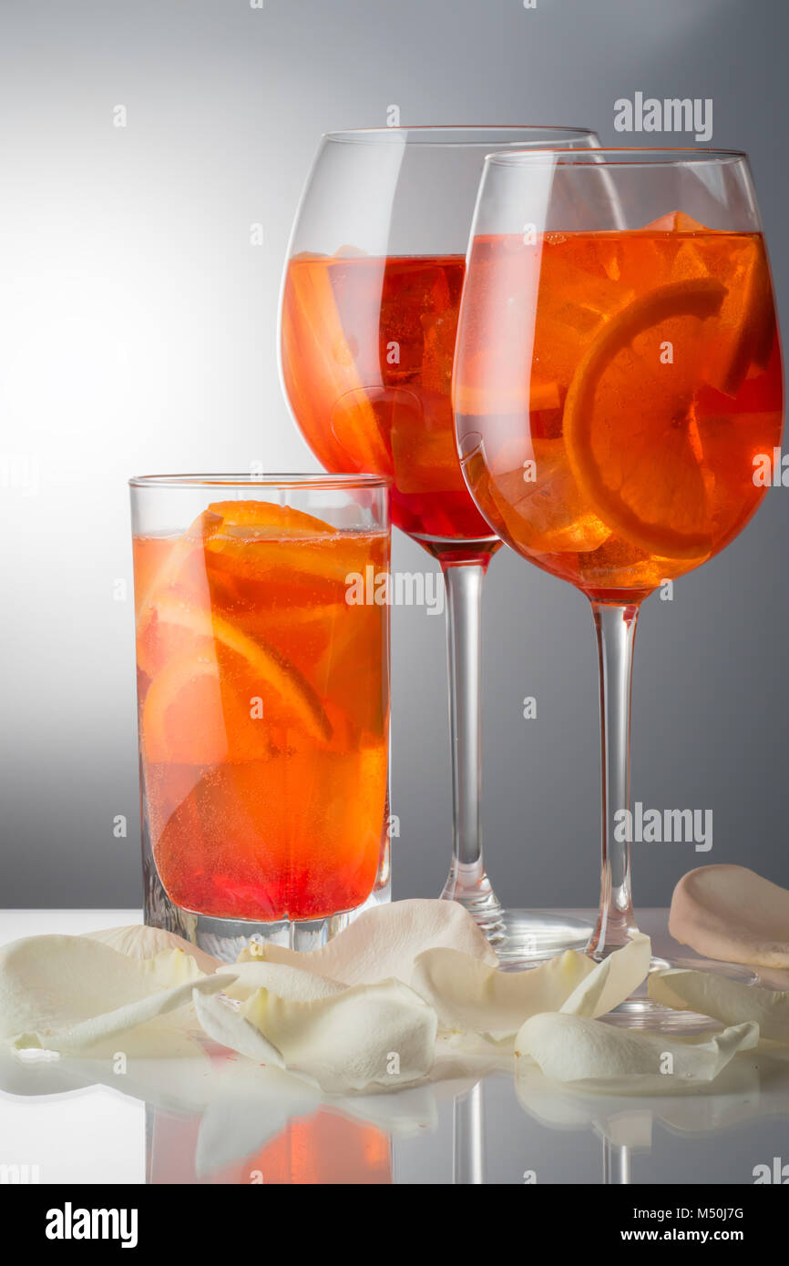 Moda italiana popolare bevanda rinfrescante estivo debolmente cocktail alcolico Aperol spritz in un bicchiere di vetro con ghiaccio decorato con fettine di arancio sulla Pentecoste Foto Stock