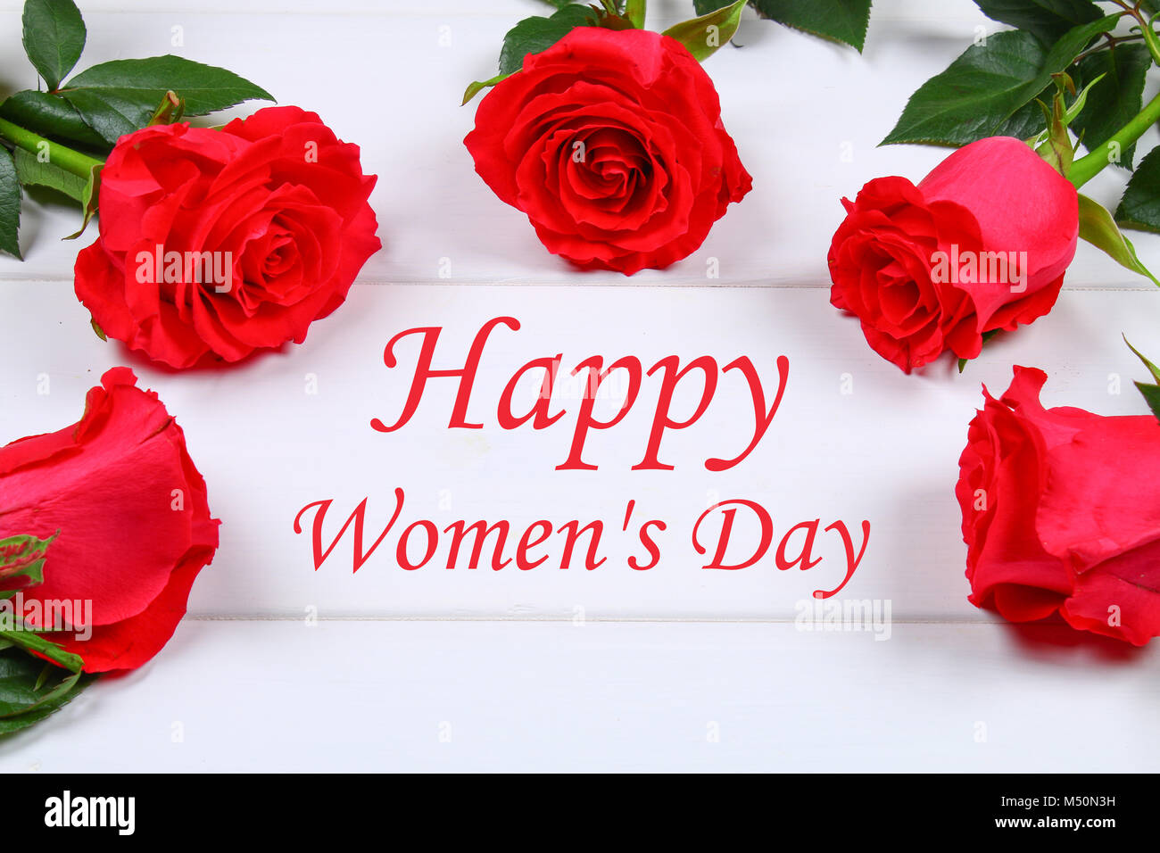 Felice Festa della donna. Il 8 marzo. Le rose su un bianco tavolo in legno  Foto stock - Alamy