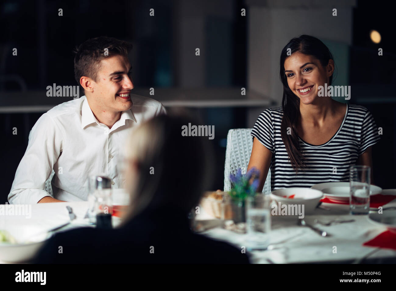 Gruppo di amici avente una cena in un ristorante.Double Data.attraente persone night out,di pranzare in un hotel alla moda.le persone che visitano un nuovo luogo aperto.B Foto Stock
