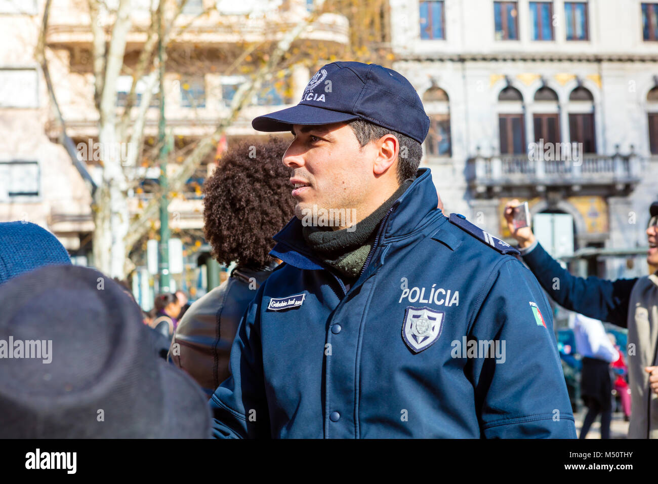 Non identificato poliziotto portoghese in una folla in Avenida da Liberdade durante una sfilata di carnevale. Foto Stock