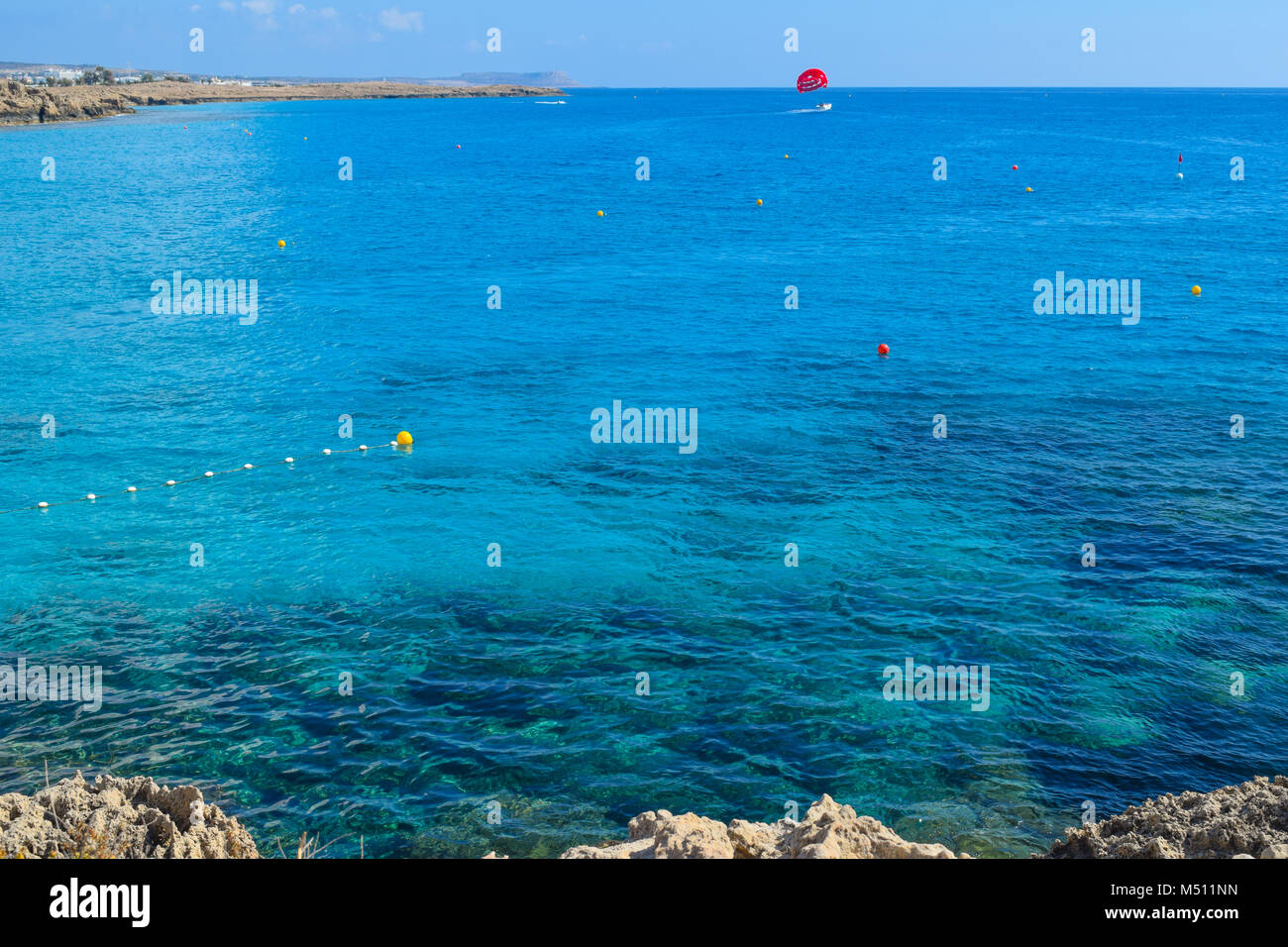 Spiaggia di Nissi parasailing, nuotare e fare surf in acqua turchese, Ayia Napa, Cipro Foto Stock
