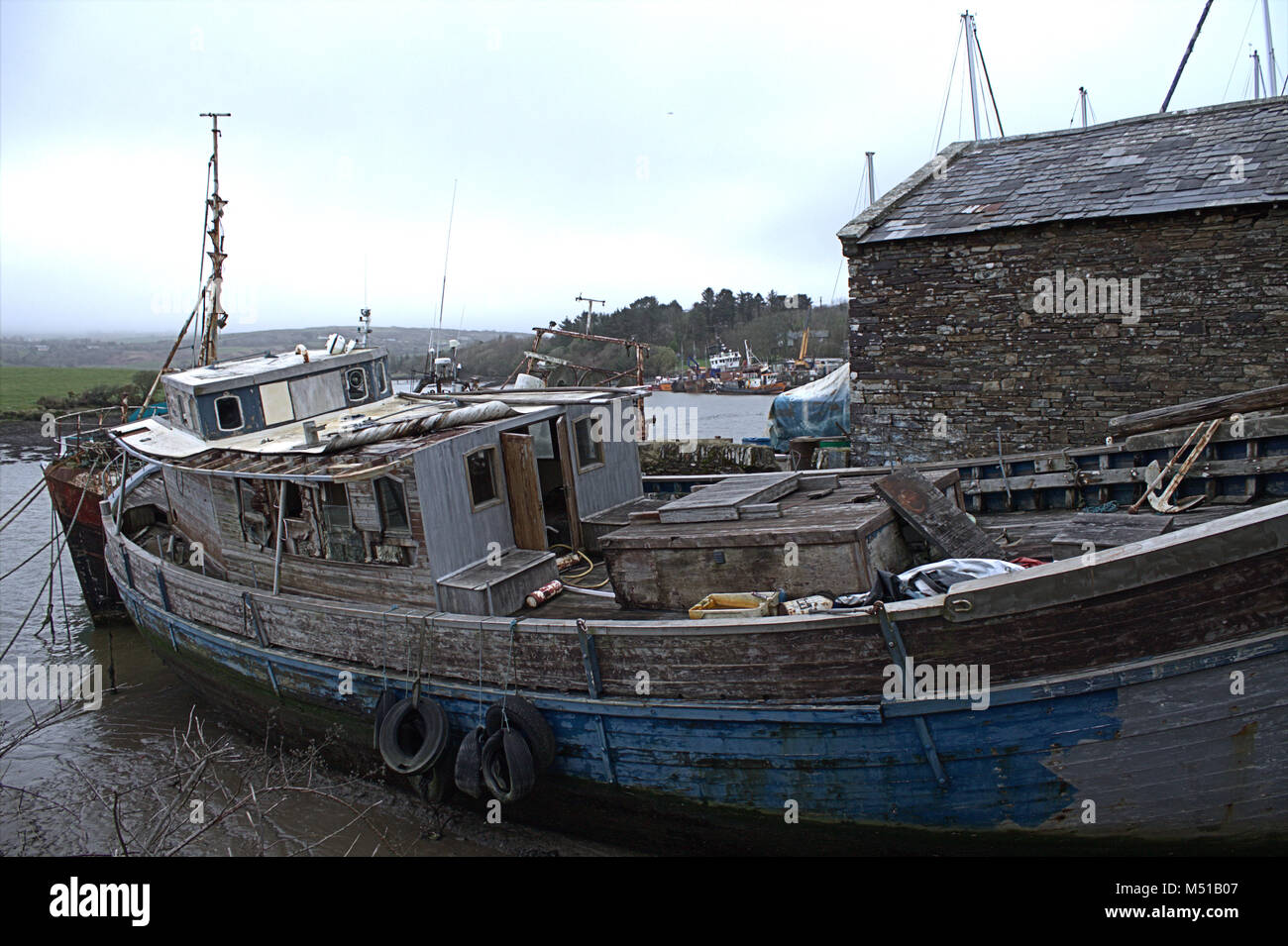 La scafo abbandonati di quella che una volta era una bella barca di legno è caduta lentamente a parte in un piccolo cantiere navale. Foto Stock