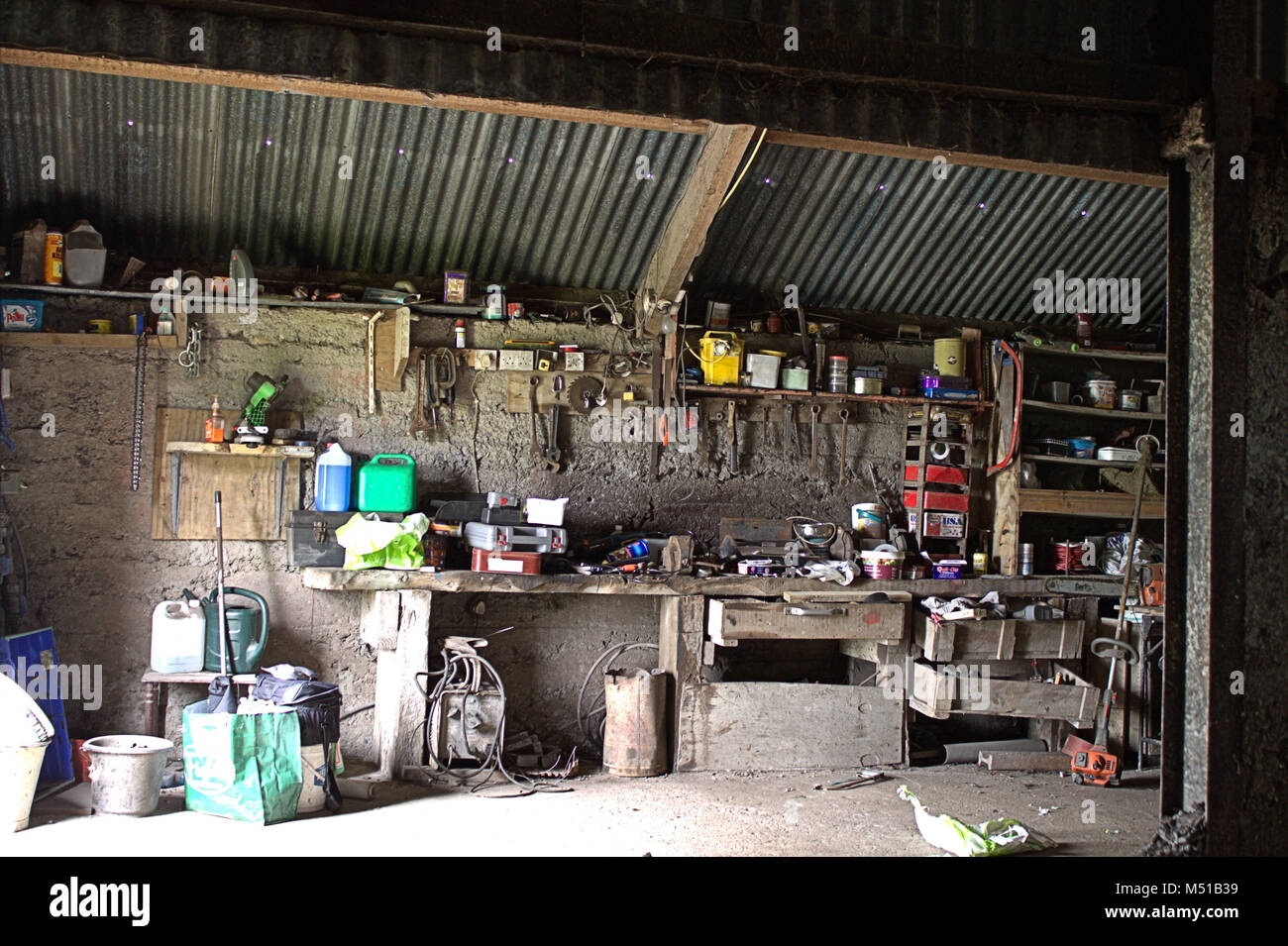 Paese tipico fienile work shop con strumenti e lattine sparse in ogni dove. Foto Stock