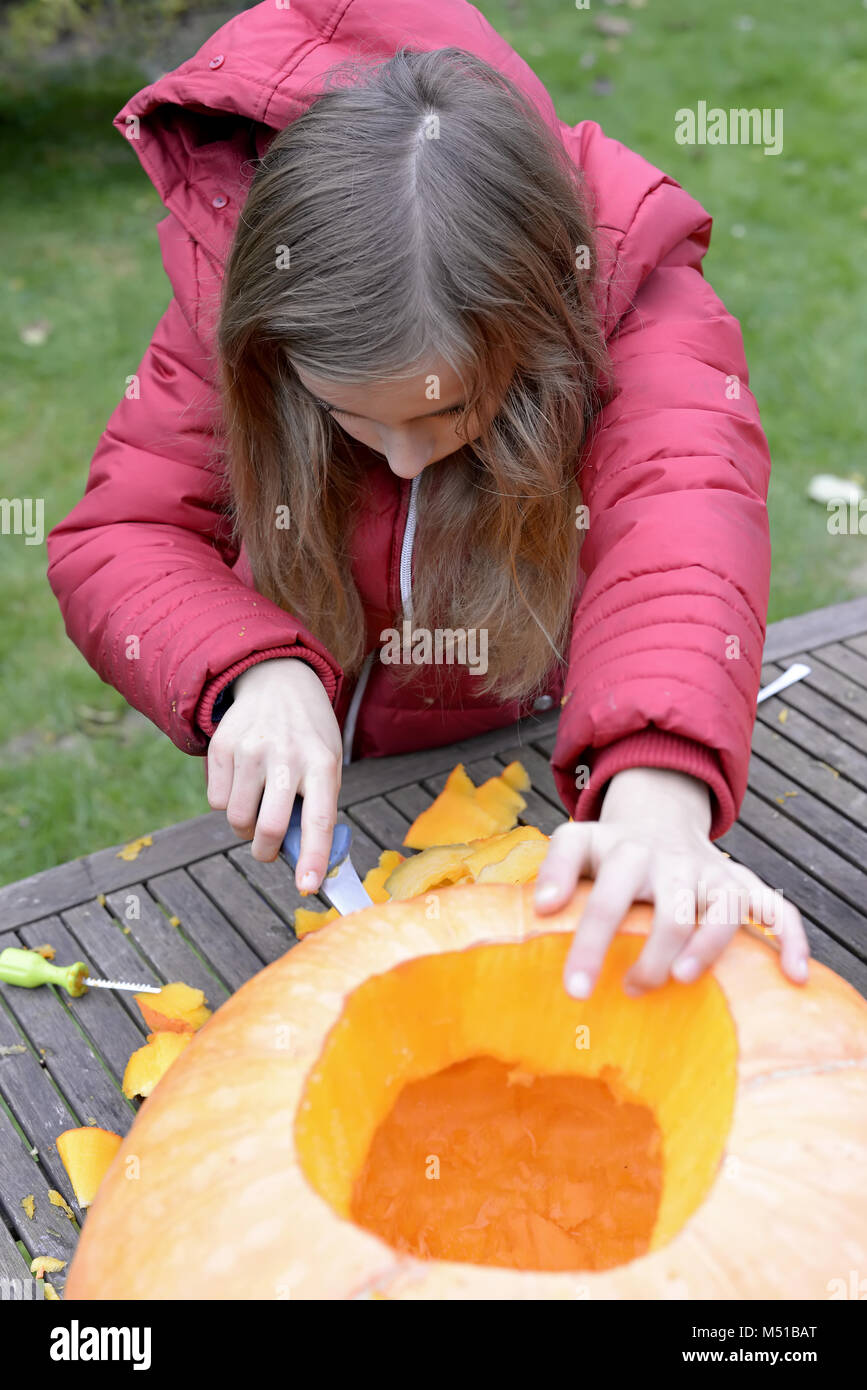 Ragazza rendendo la zucca di Halloween Foto Stock