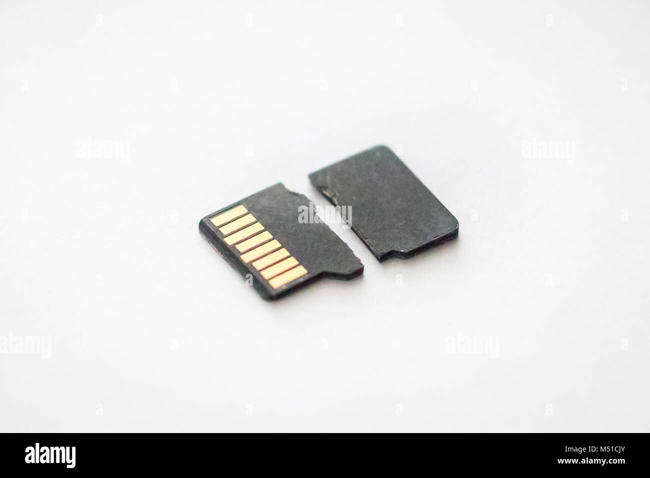 Rotto distrutto micro SD card sulla superficie bianca vicino Foto Stock