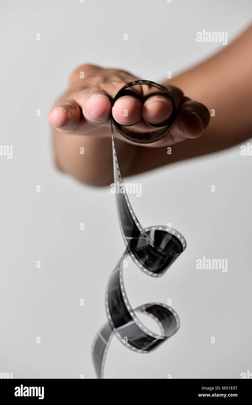 Primo piano di un giovane uomo caucasico con una pellicola laminata in mano, come egli era plagying con uno yo-yo, contro un fondo bianco Foto Stock