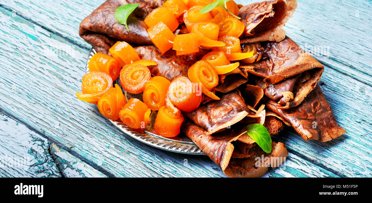 Frittelle con marmellata di colore arancione su sfondo di legno Foto Stock