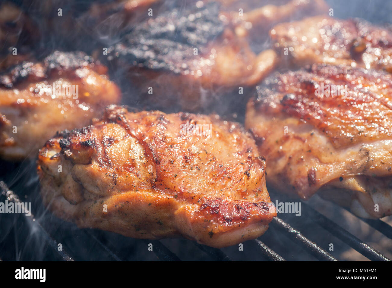 Grigliata di coscia di pollo sulla griglia fiammeggianti Foto Stock