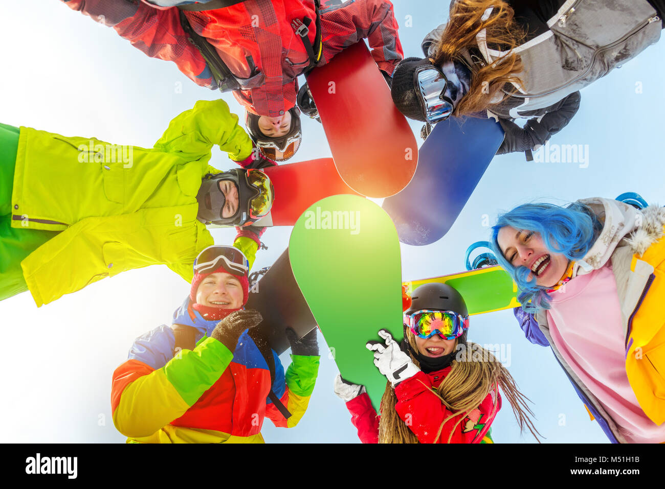 Gruppo di amici felice sorge in cerchio con gli snowboard Foto Stock