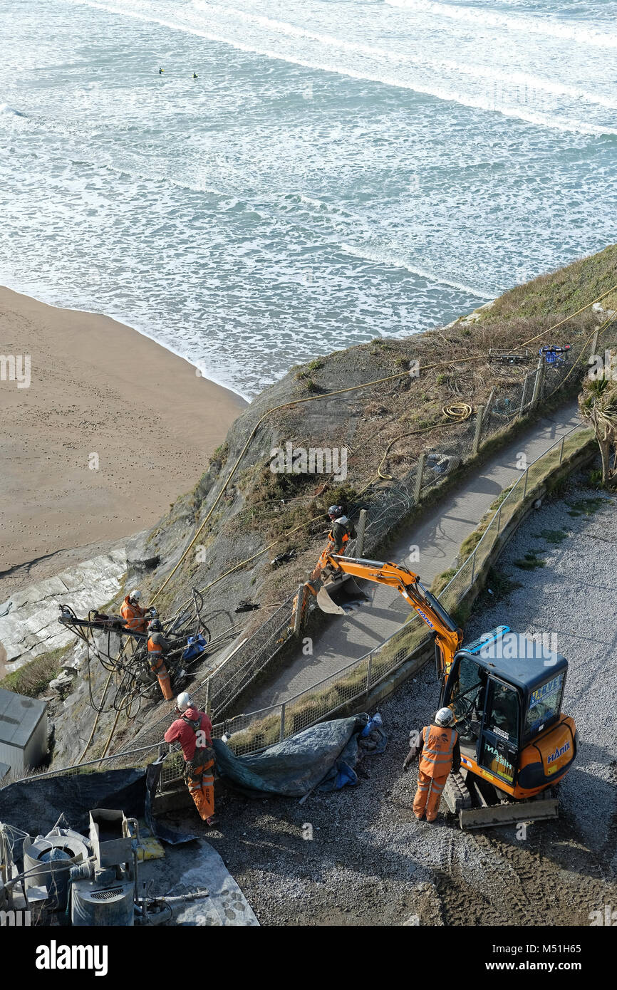 Uomini al lavoro sulla scogliera di riparazioni in Newquay, Cornwall. Foto Stock