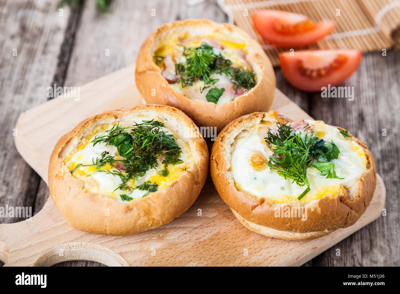 Uova strapazzate con formaggio e bacon in un panino. Una gustosa prima colazione. Foto Stock