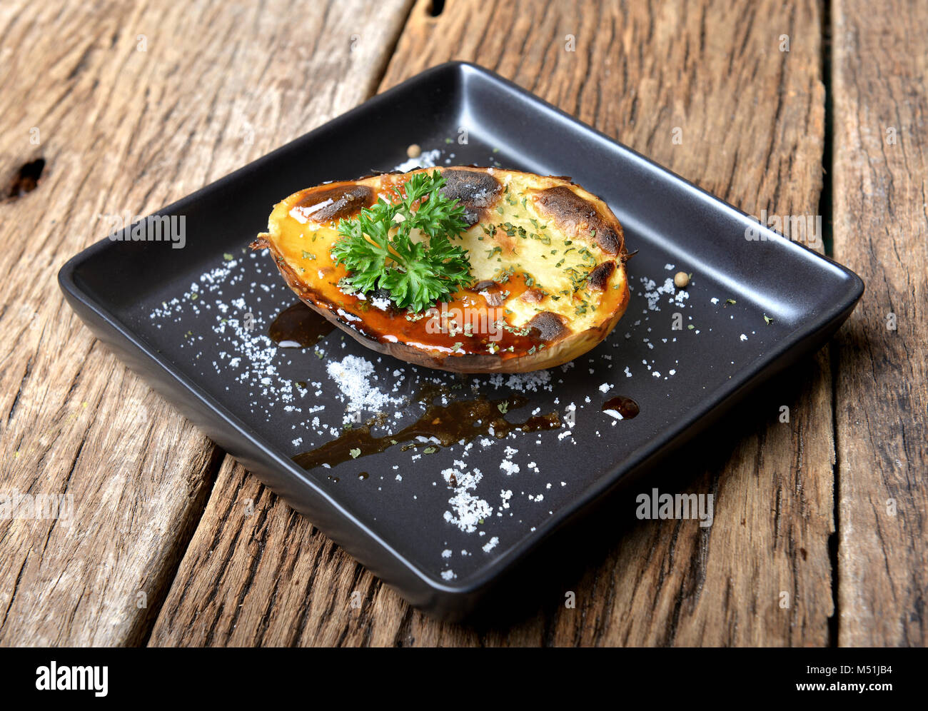 Patate cotte al forno e grill a carbone fuoco aggiungere BBQ SAUCE per appertizer in esterni e illuminazione flash. Foto Stock