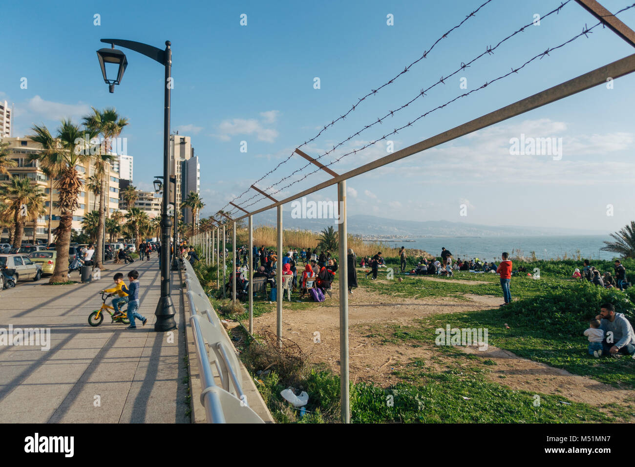 Famiglie giocare sull'erba per la spiaggia in un bel pomeriggio di sole in una zona che una volta era recintata-off a Beirut, Libano Foto Stock