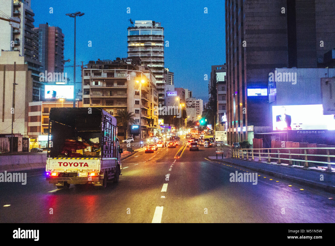 Un piccolo carrello capi lungo la strada in Beirut luminose luci della città una sera Foto Stock