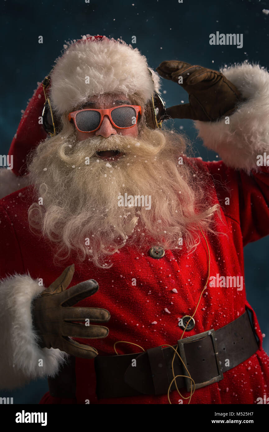 Babbo Natale è l'ascolto di musica in cuffia indossando occhiali da sole.  Natale Foto stock - Alamy