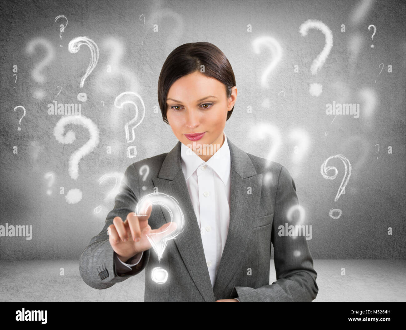 Business donna con simboli questione intorno a lei. La scelta di uno e premendo su di essa Foto Stock