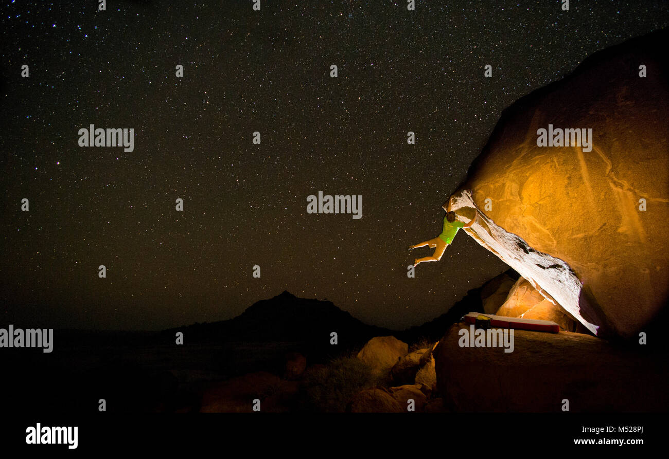 L'uomo bouldering sotto il cielo stellato di notte, Spitzkoppe, Regione di Erongo, Namibia Foto Stock