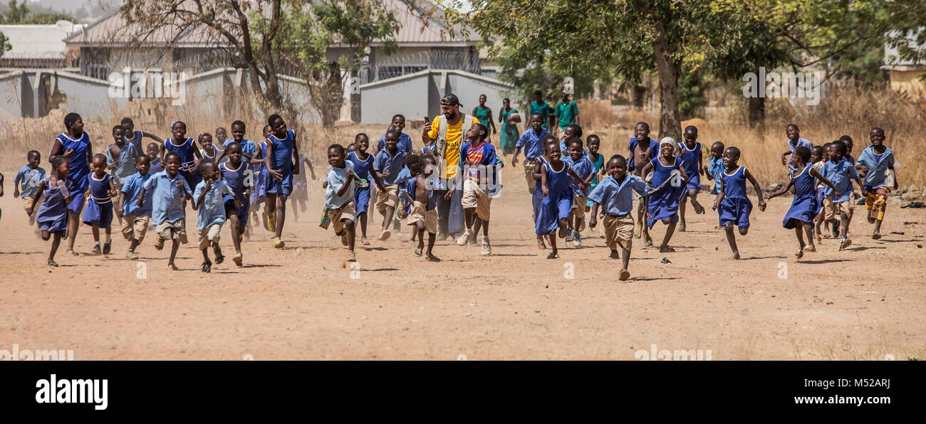 I bambini in esecuzione insieme a TimTooni Football Club, appena fuori Tamale nel nord del Ghana. Insieme con gli allenatori di calcio da Londra, tempo trascorso con i bambini qui insegnando loro nuove abilità e terminante con un grande gioco di calcio. Queste aree del Ghana sono così remote e i livelli di povertà sono alcuni tra i più bassi del mondo. Foto Stock