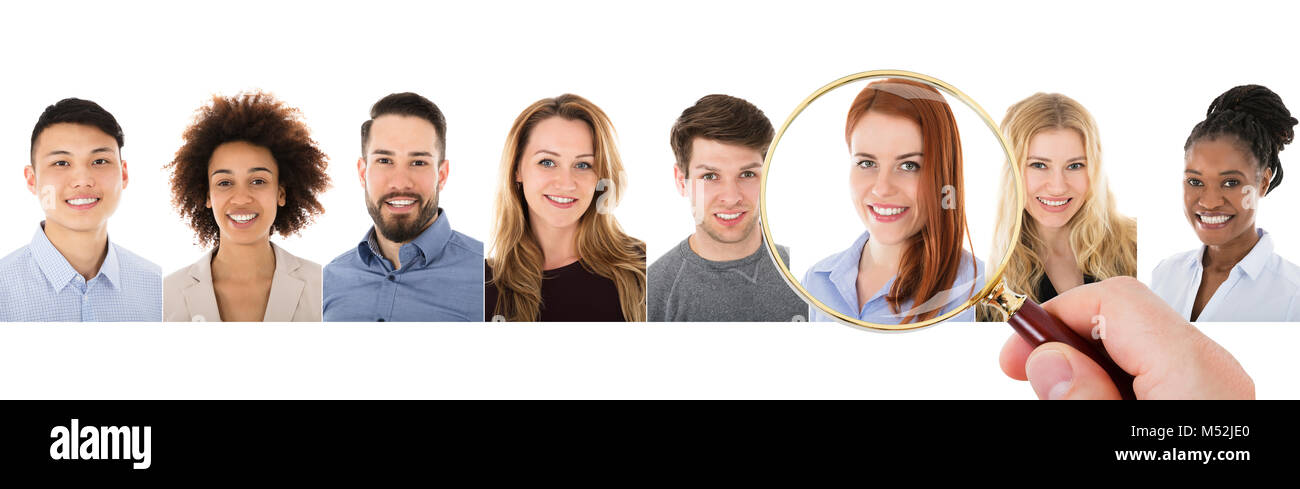 Close-up di persona la mano con lente di ingrandimento su femmina candidato per l'assunzione Foto Stock