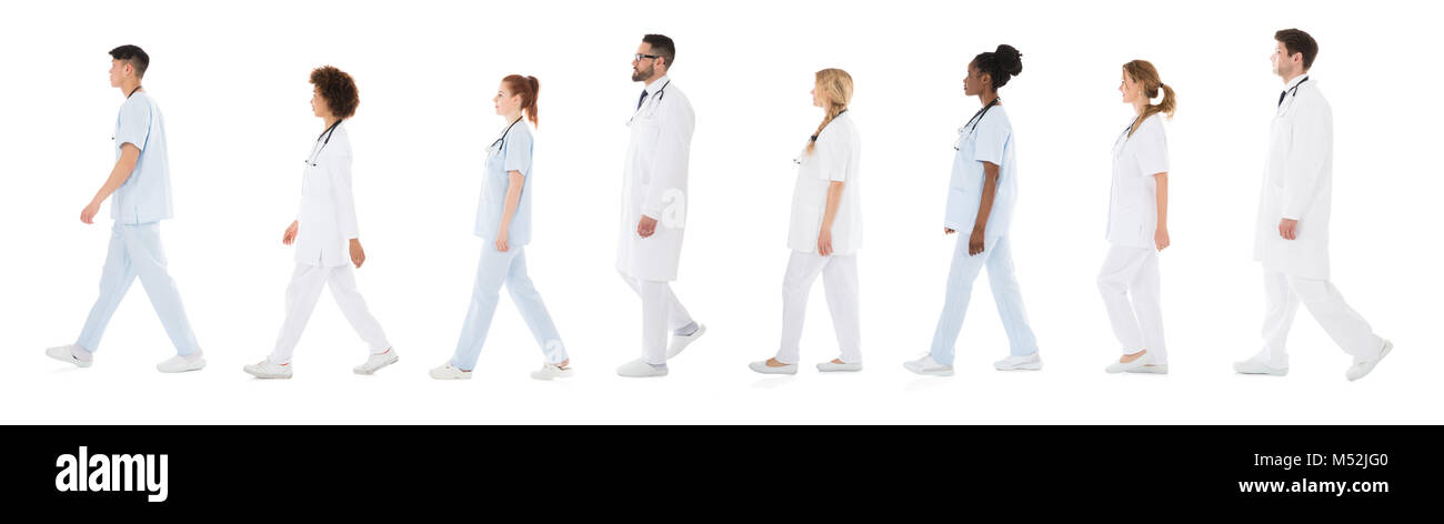 Il gruppo di medici a camminare in una riga su sfondo bianco Foto Stock
