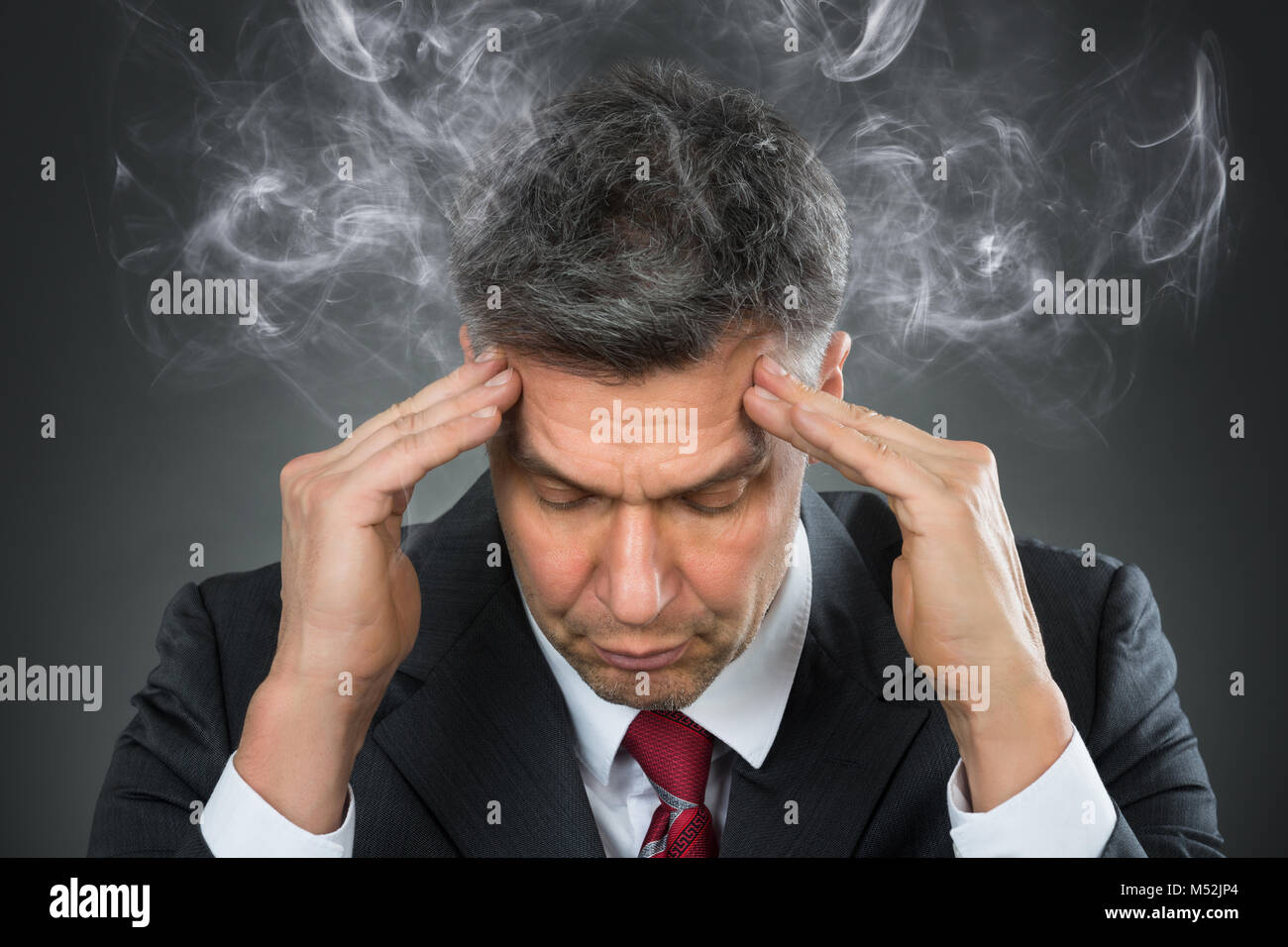 Ritratto di imprenditore maturo che soffrono di mal di testa Foto Stock
