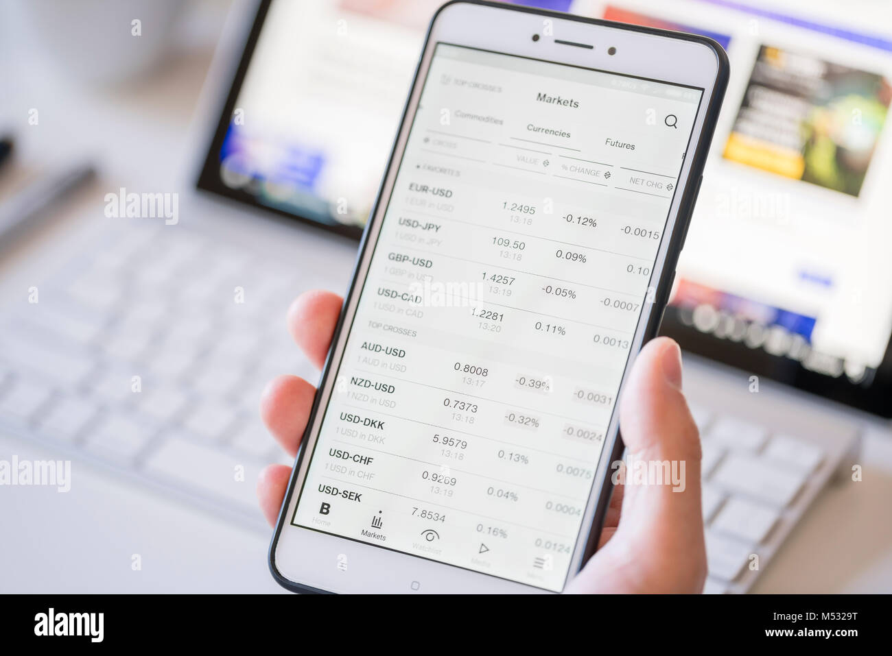 Controllare i tassi di cambio su uno smartphone Foto Stock