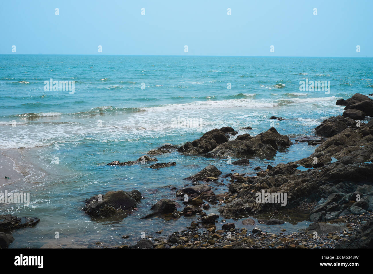 Onde lisce di colpire la riva Foto Stock