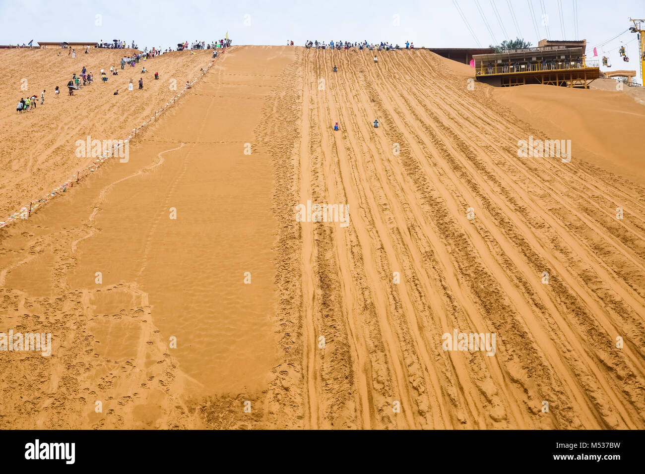 Lo scorrimento nella sabbia del deserto sullo sfondo del turismo Foto Stock