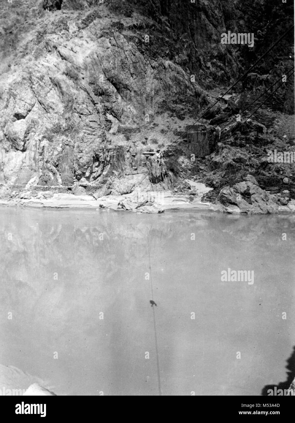 K. HOWARD a metà strada attraverso il cavo ruggine oltre il Fiume Colorado vicino PHANTOM RANCH. HOWARD è di attraversare il fiume a mano e non con la funivia. Da William H. CLAFLIN ALBUM FOTOGRAFICO (catalogo # GRCA 21089). Data: 1914 Grand Canyon Parco Nat storica sul fiume foto. Foto Stock