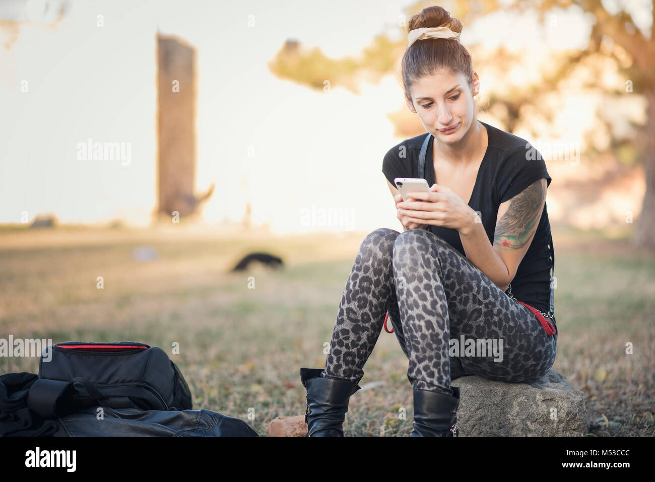 Alternativa di giovane donna seduta nel parco Foto Stock