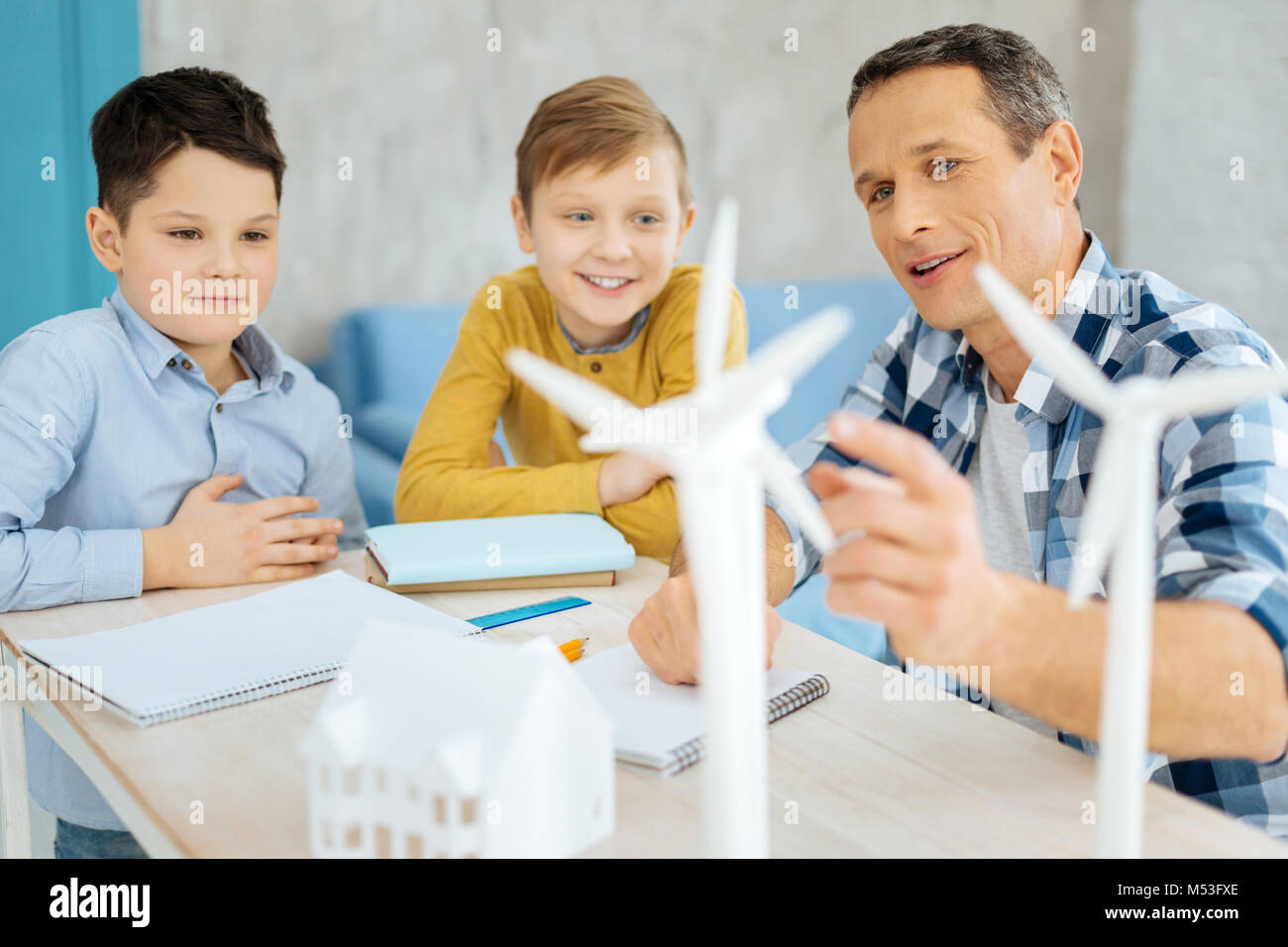 Upbeat padre e i suoi figli a discutere di costruzione di turbine eoliche Foto Stock