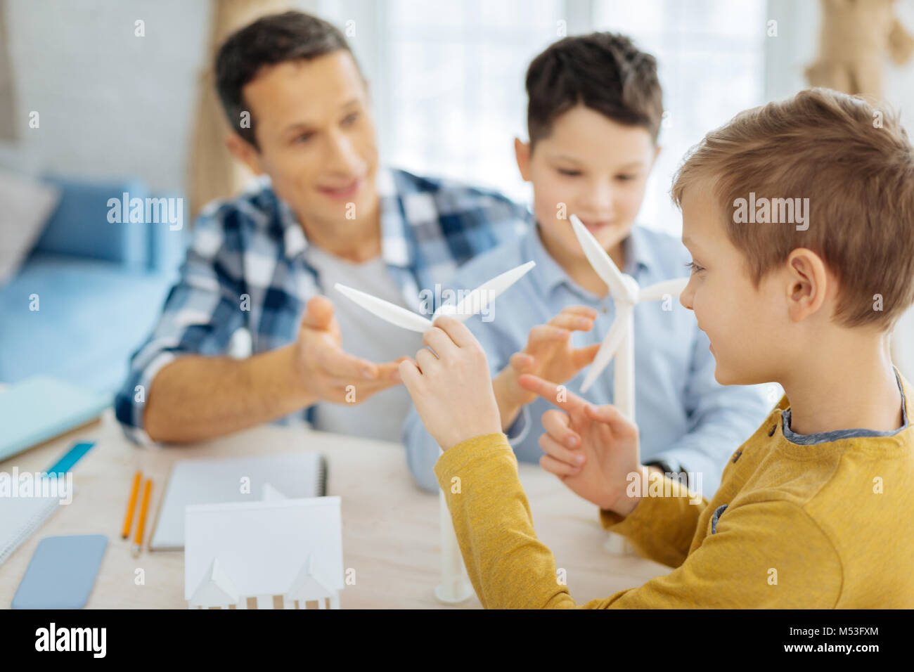 Pre-teen boy esaminando le turbine eoliche in ufficio dei padri Foto Stock