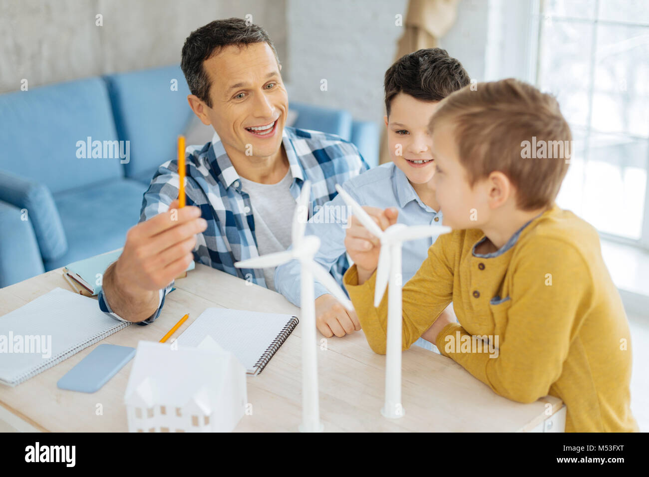 Padre Felice chiacchierando allegramente con figli circa il suo lavoro Foto Stock