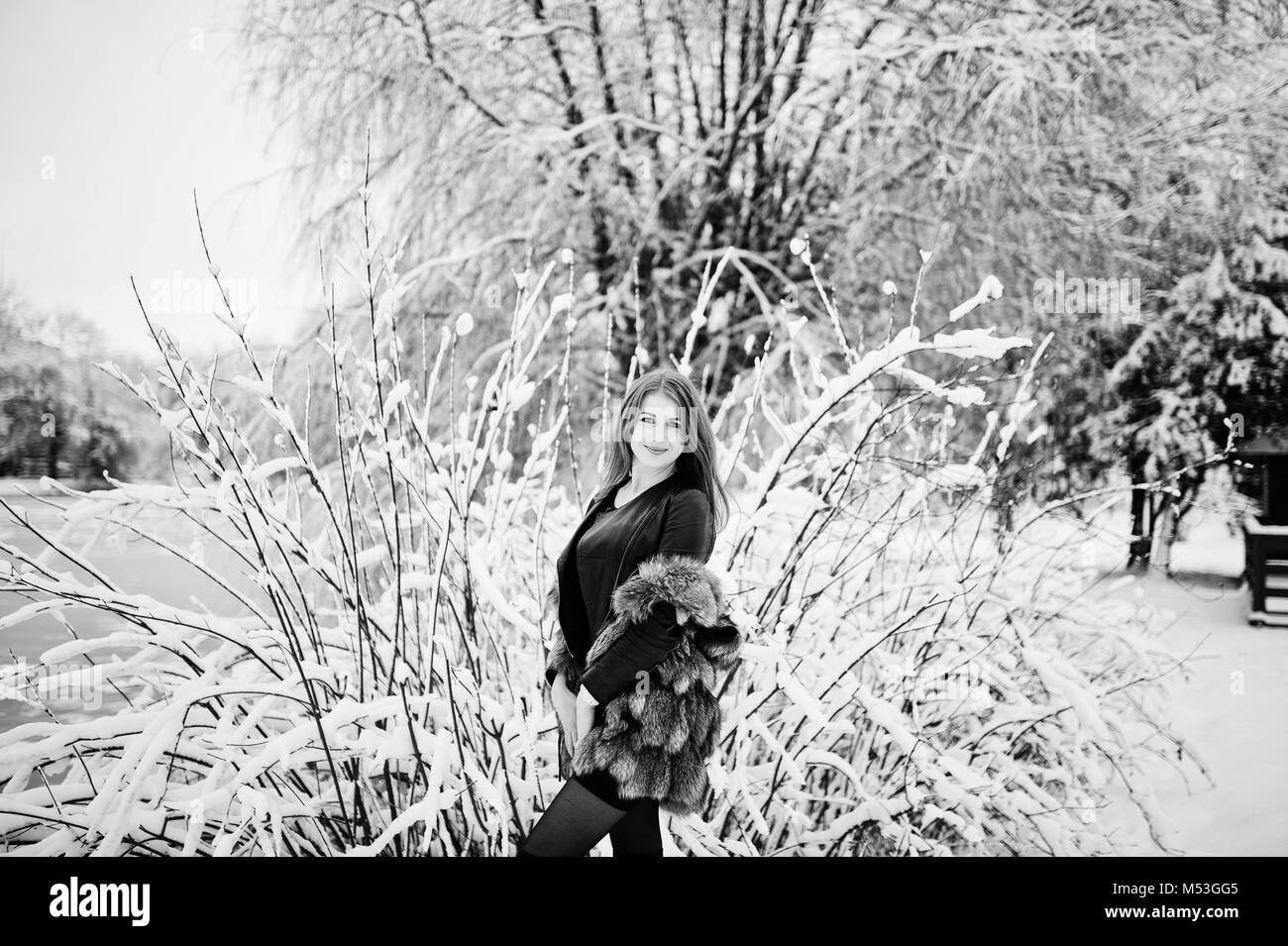 Dai Capelli rossi ragazza in pelliccia a piedi di inverno parco innevato. Foto Stock