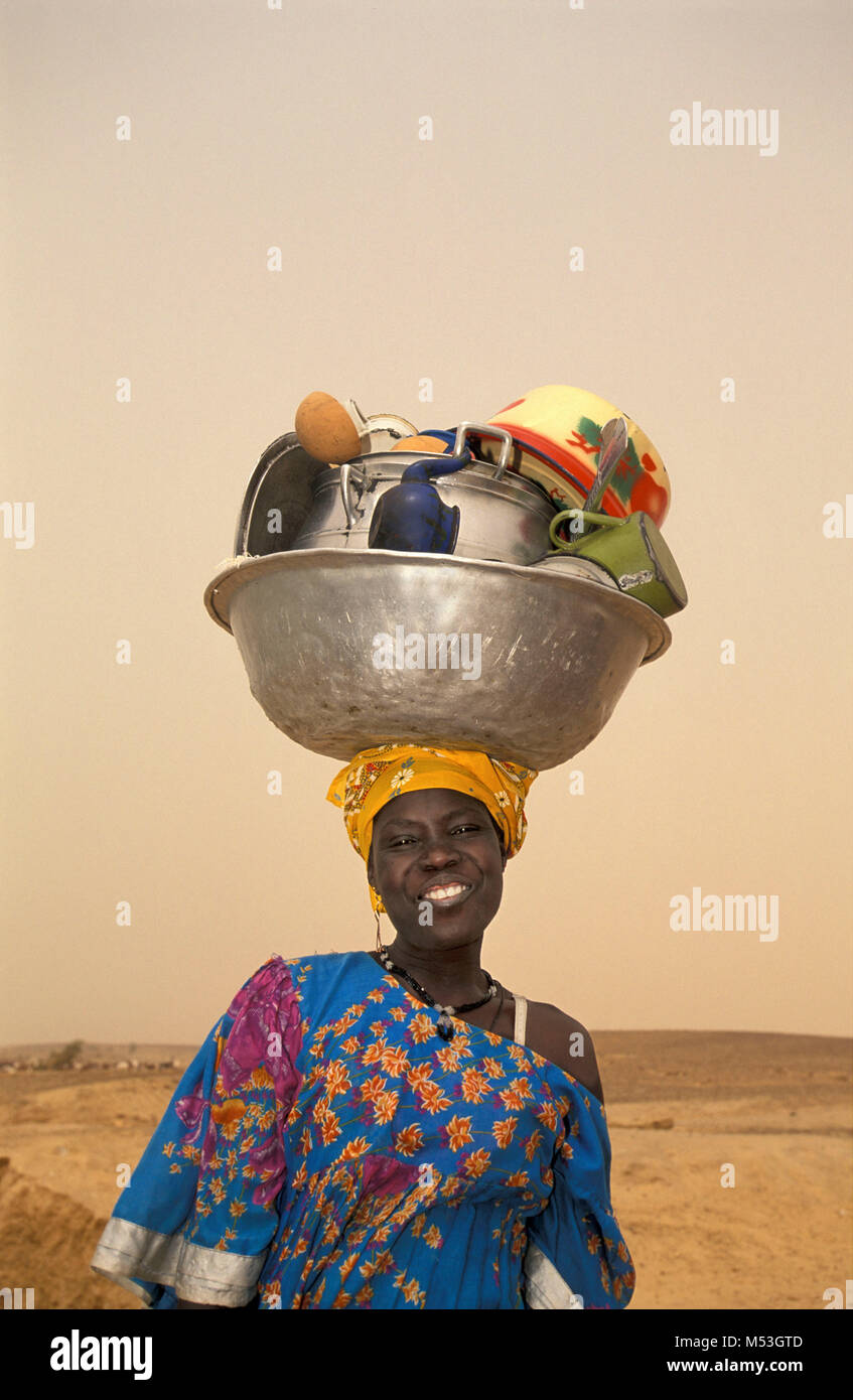Mali. Timbuctu. Deserto del Sahara. Il Sahel. Songhai, Songrai tribù. La donna torna a casa da lavare i piatti in fiume Niger, piatti che porta sulla testa. Foto Stock