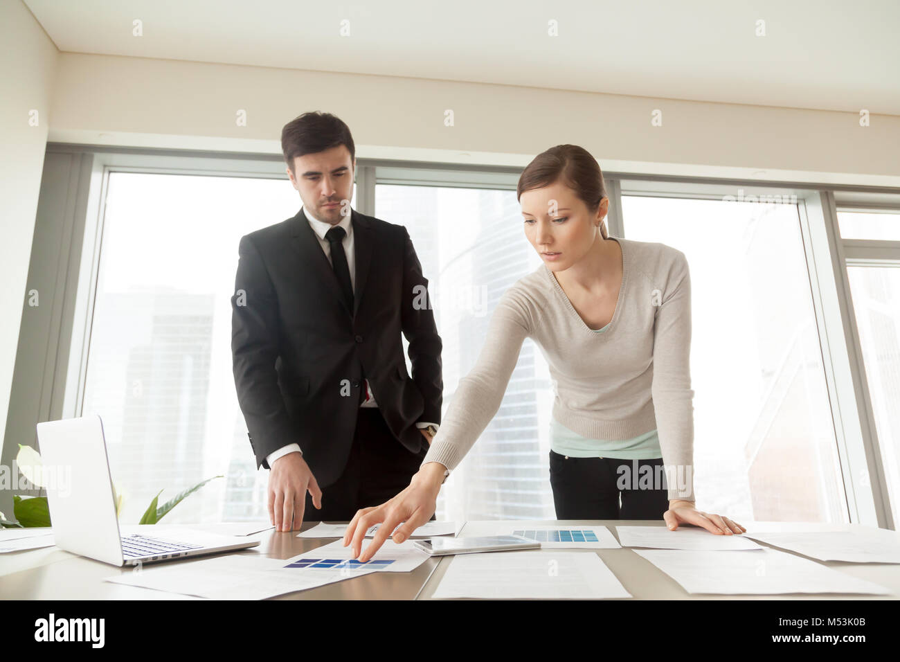 Donna scegliendo il colore della vernice con designer di interni Foto Stock