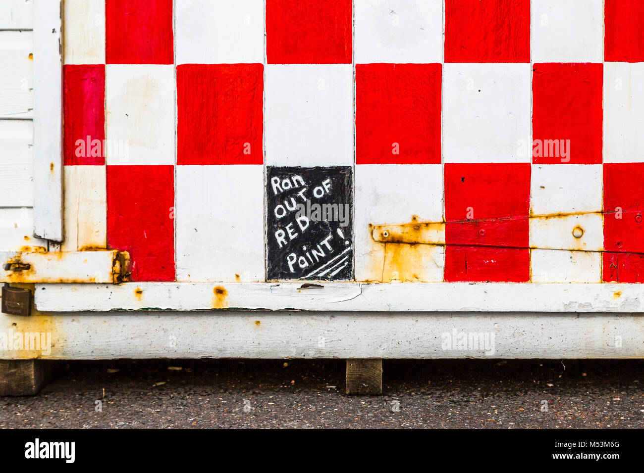 Eseguire al di fuori del segno di vernice su un Red & White capannone porta. Foto Stock