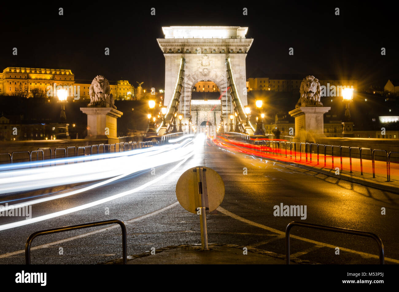Scena notturna illuminata del Ponte della Catena che si estende sul fiume Danubio, Budapest, Ungheria. Rosso e bianco auto sentieri, lunga esposizione Foto Stock