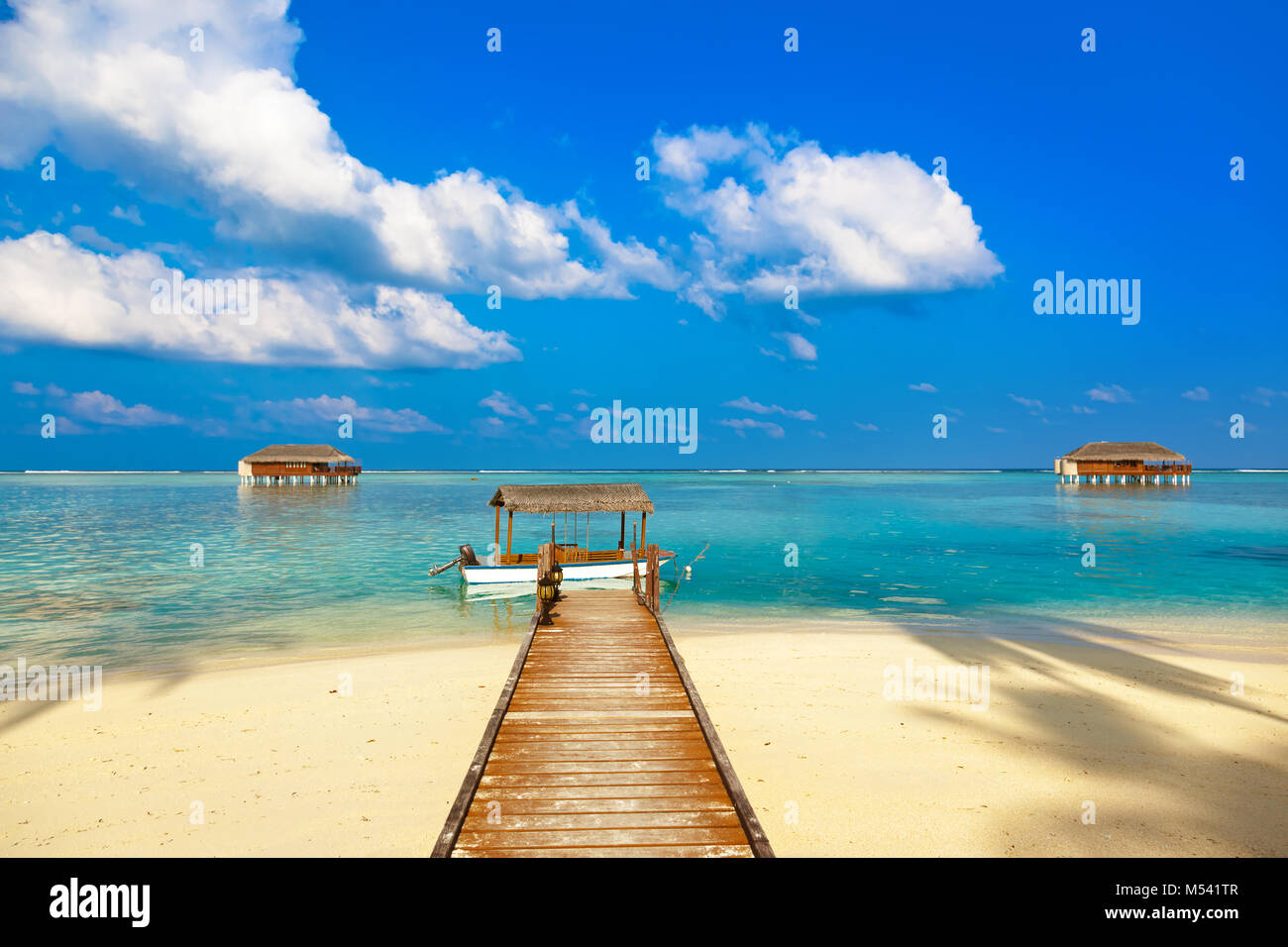 Barca e bungalow sull isola di Maldive Foto Stock