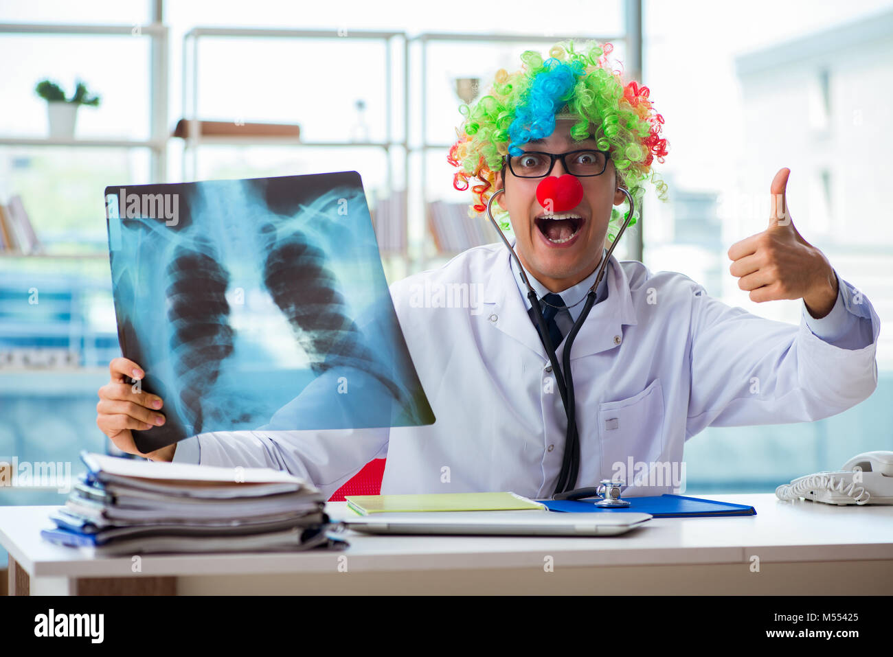 Pediatra con immagine a raggi x seduta in ufficio Foto Stock